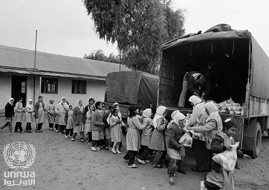 Schoolgirls line up to collect UNRWA food parcels in Gaza
